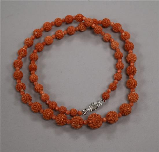 A single strand carved coral bead necklace with coral coloured spacers and diamond set clasp, 51cm.